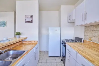 a kitchen with white cabinets and a white refrigerator at Rentamos Aparta Estudio for short or long stay in Santo Domingo
