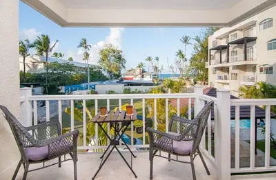 a balcony with two chairs and a table and a view of the ocean at A pasos de la playa cerca de bares y restaurantes in Punta Cana