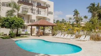 a swimming pool in front of a building at A pasos de la playa cerca de bares y restaurantes in Punta Cana