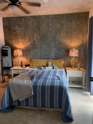 a bedroom with a bed with two tables and two lamps at VILLA GRANDEZZA in Punta Cana