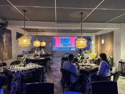 a group of people sitting at tables in a restaurant at VILLA GRANDEZZA in Punta Cana