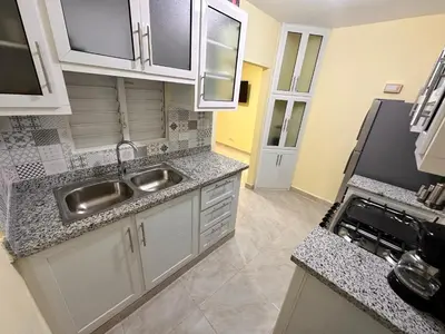 a kitchen with white cabinets and a stainless steel sink at Our Cozy Home, Wi-Fi, AC, Parking, Near Beaches and Attractions in quiet area in Nagua
