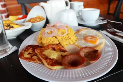 a white plate with breakfast foods on a table at Hotel Merey in Santo Domingo