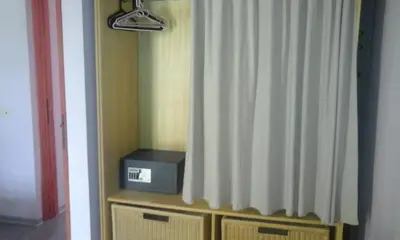 a room with a curtain and a box on a dresser at Residencial Las Palmeras de Willy Boca Chica in Boca Chica