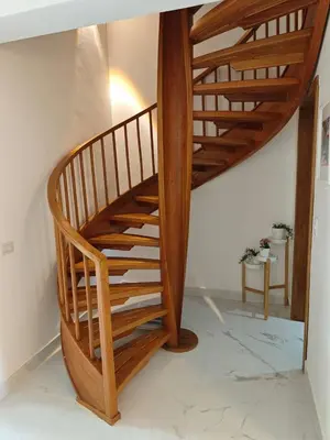 a wooden spiral staircase in a living room at Residencial Las Palmeras de Willy Boca Chica in Boca Chica