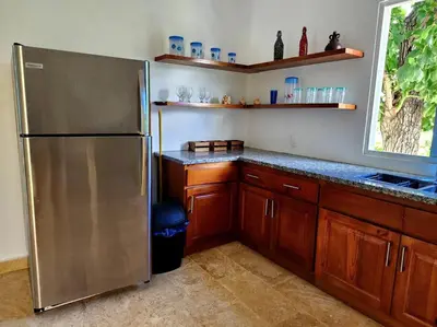 a kitchen with a stainless steel refrigerator and wooden cabinets at Bella Villa Roomy apartment at 5 min walk to the beach in Las Galeras