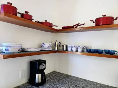 a kitchen with wooden shelves and pots and pans at Bella Villa Roomy apartment at 5 min walk to the beach in Las Galeras