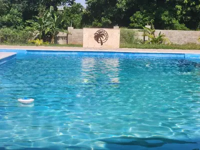 a pool of blue water with a sign in the background at Bella Villa Roomy apartment at 5 min walk to the beach in Las Galeras
