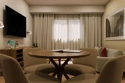 a living room with a table and chairs and a couch at Wyndham Garden El Morro Montecristi in El Rincón