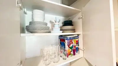 a cupboard with plates and glasses and dishes at Cozy apartment Golf Course View in Punta Cana in Punta Cana