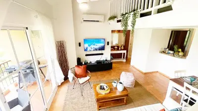 a living room with a couch and a tv at Cozy apartment Golf Course View in Punta Cana in Punta Cana