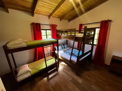 a room with three bunk beds in a house at Villa unter Palmen in Jarabacoa