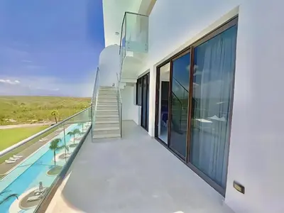 a balcony of a house with a swimming pool at Ph in Cana Rock Star With Golf View And Pool in Punta Cana