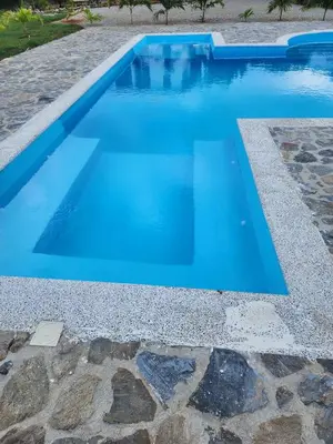 a swimming pool with blue water in a yard at Bella Villa room with large pool and close to beach in Las Galeras