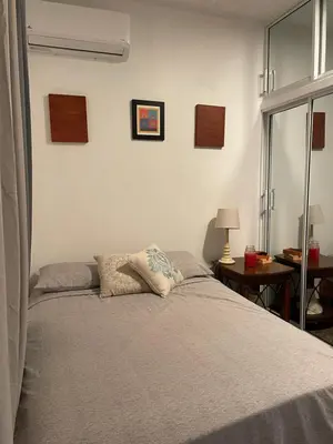 a bedroom with a bed and a table with a lamp at Casa Jacaranda -10 pax, Cerca de la Playa in Las Galeras