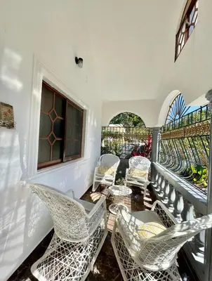 a balcony with chairs and a window at Casa Jacaranda -10 pax, Cerca de la Playa in Las Galeras