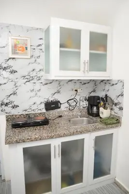 a kitchen counter with white cabinets and a sink at APARTAMENTOS DE 1 2 Y 3 HABITACIONEs in Santiago de los Caballeros