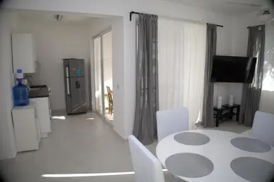 a white dining room with a table and chairs at Tamarindo Dominicus by Mireya in La Laguna