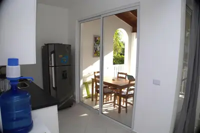 a kitchen with a sliding glass door with a table and a refrigerator at Tamarindo Dominicus by Mireya in La Laguna