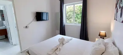a bedroom with a white bed with a window at Tamarindo Dominicus by Mireya in La Laguna