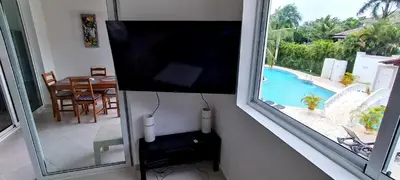 a flat screen tv hanging on a wall in a living room at Tamarindo Dominicus by Mireya in La Laguna