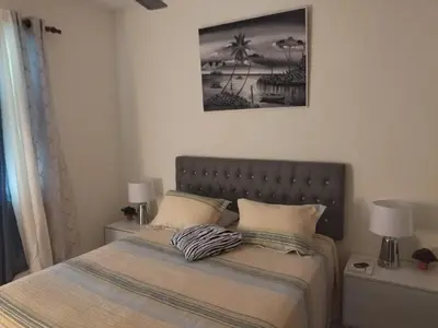 a bedroom with a bed with two lamps and a picture at Condo Penthouse Batey Dominicus in Bayahibe