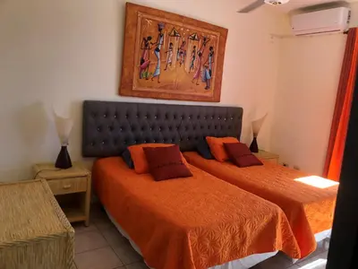 a bedroom with two beds and a painting on the wall at Condo Penthouse Batey Dominicus in Bayahibe