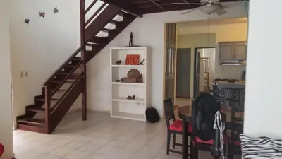 a living room with a staircase and a table at Condo Penthouse Batey Dominicus in Bayahibe