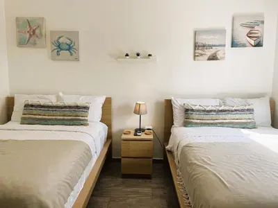 a bedroom with two beds and a nightstand between them at Arena Village | 2H Retiro con Vista a Piscina in Punta Cana