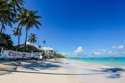 a sandy beach with palm trees and the ocean at Arena Village | 2H Retiro con Vista a Piscina in Punta Cana