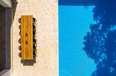 a yellow bench on the side of a swimming pool at Villa Collie Luxury Retreat7 King Master BRMaid in Sosúa