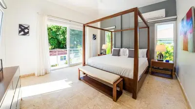 a bedroom with a canopy bed and a large window at Villa Collie Luxury Retreat7 King Master BRMaid in Sosúa