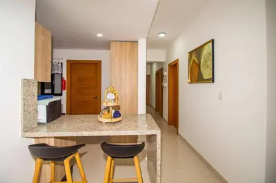 a kitchen with two bar stools and a counter top at Brand New Luxury Home in Santo Domingo