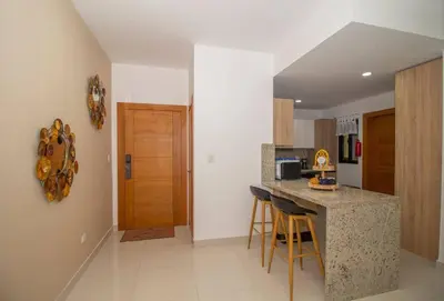 a kitchen with a counter and stools in a room at Brand New Luxury Home in Santo Domingo