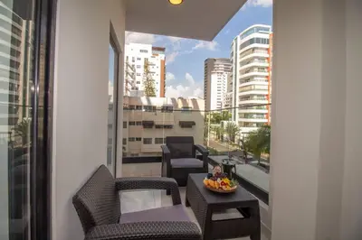 a balcony with chairs and a table and a view of a city at Brand New Luxury Home in Santo Domingo