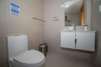 a bathroom with a white toilet and a sink at Brand New Luxury Home in Santo Domingo