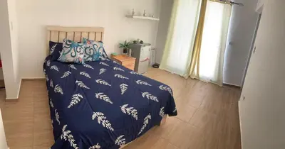 a bedroom with a bed with a blue comforter at La Isla Bonita in Punta Rucia