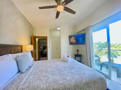 a bedroom with a large bed with a ceiling fan at Cozy City Center Condo, Full AC in Los Prados