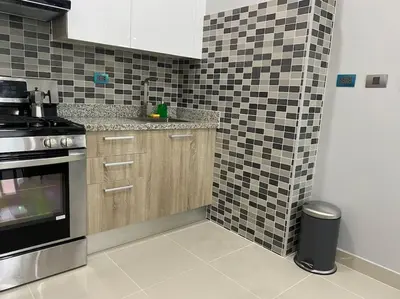 a kitchen with black and white tiles on the wall at Cozy City Center Condo Full AC in Santo Domingo
