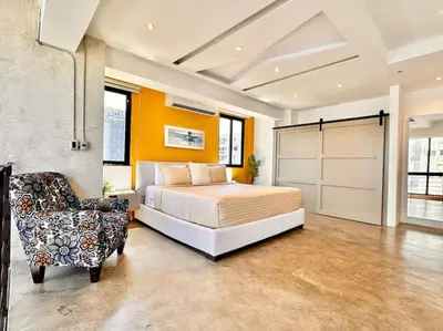 a bedroom with a bed and a chair at New Loft Apt Full AC King Bed in Santo Domingo