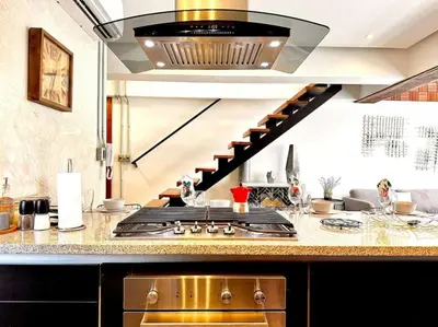 a kitchen with a stove and a staircase at New Loft Apt Full AC King Bed in Santo Domingo