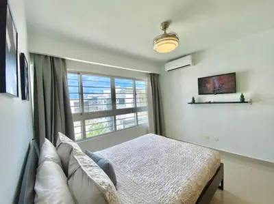 a bedroom with a bed and a large window at Stylish Apt Full AC King Bed in Los Prados