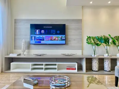 a living room with a tv on a wall at Lovely Sto Dgo Center Apt in Santo Domingo