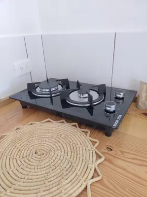 a black stove with three burners on top of a wooden floor at Quédate Aquí in Las Galeras