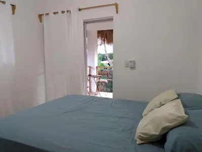 a bedroom with a bed with a blue comforter at Quédate Aquí in Las Galeras