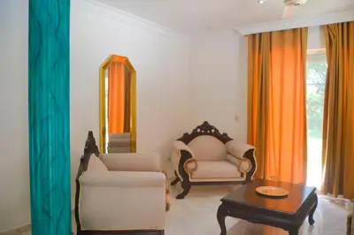 a living room with a chair and a table and a mirror at Casa angelina in Sosúa