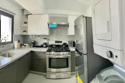 a kitchen with a stainless steel stove and refrigerator at Lovely City Center Condo in Los Prados