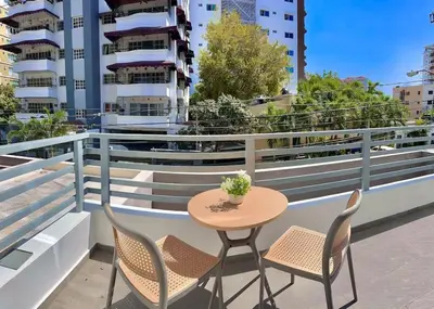 a table and chairs on a balcony with buildings at Beautiful Condo in Bella Vista in Los Prados