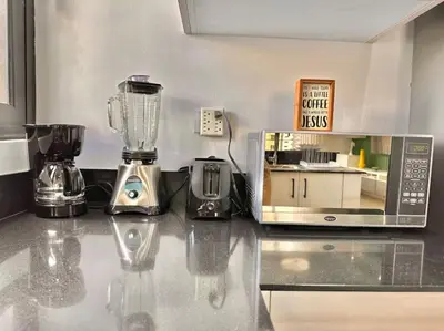 a kitchen counter with a blender and a microwave at Stunning City Center Condo in Los Prados