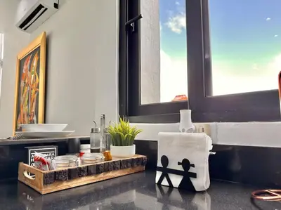 a bathroom with a counter with a sink and a window at Stunning City Center Condo in Los Prados